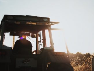 Un paysan sur son tracteur, au coucher de soleil