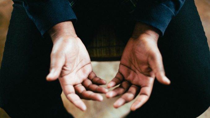 Une personne tendant les deux mains pour prier
