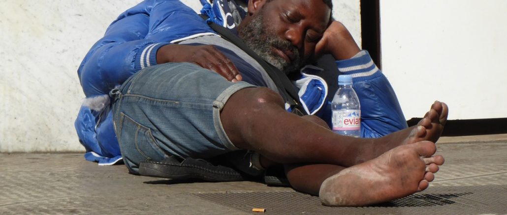 Un sans-abri allongé dans la rue.