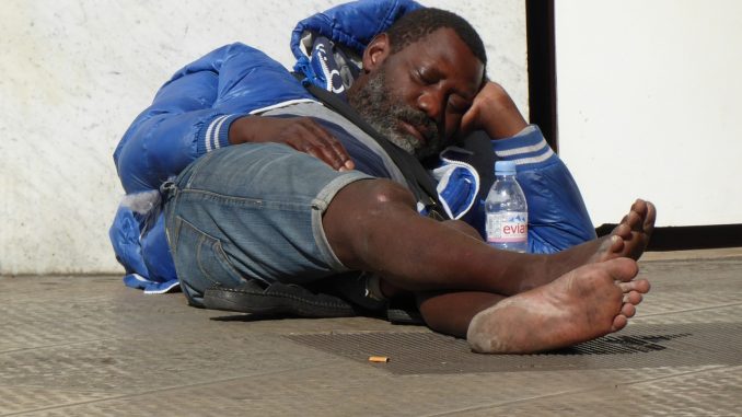 Un sans-abri allongé dans la rue.
